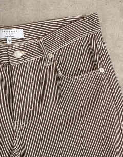 Model wearing Cinch low rise relaxed fit jean in choc stripe