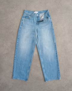 Model wearing Cinch low rise relaxed jean in bleach - LBLUE