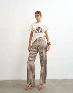 Model wearing Cinch low rise relaxed jean in tobacco and colbalt stripe
