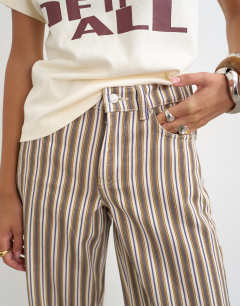 Model wearing Cinch low rise relaxed jean in tobacco and colbalt stripe