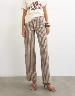 Model wearing Cinch low rise relaxed jean in tobacco and colbalt stripe