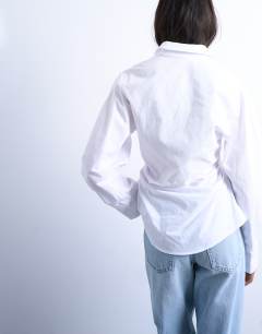 Model wearing Cinch waisted long sleeve shirt in white