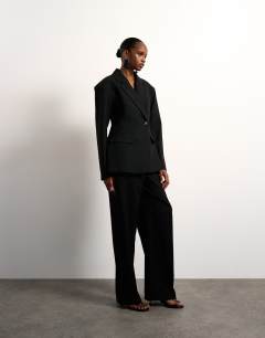 Model wearing Cinched padded shoulder blazer in black