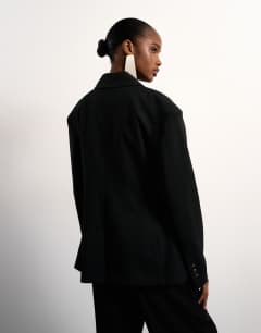 Model wearing Cinched padded shoulder blazer in black