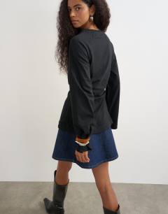 Model wearing Cinched waist long sleeve raglan t-shirt in black