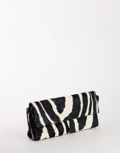Model wearing Clark medium hair on real leather fold over clutch bag in zebra