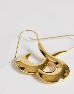 Model wearing Claudia waterproof wavy drop hoop earrings in stainless gold