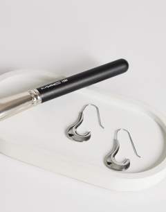 Model wearing Claudia waterproof wavy drop hoop earrings in stainless silver