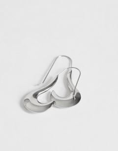 Model wearing Claudia waterproof wavy drop hoop earrings in stainless silver