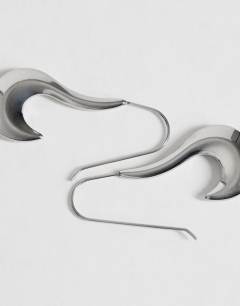 Model wearing Claudia waterproof wavy drop hoop earrings in stainless silver