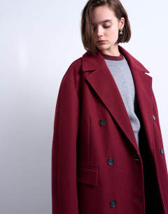 Model wearing Clean double breasted longline coat in burgundy