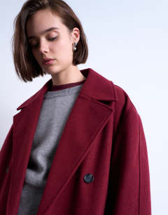 Model wearing Clean double breasted longline coat in burgundy