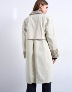 Model wearing Clean front trench with contrast check in neutral