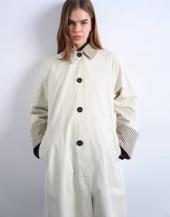 Model wearing Clean front trench with contrast check in neutral