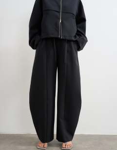 Model wearing Co ord barrel leg trouser in black 