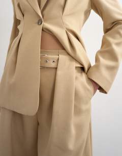 Model wearing Co ord belted highwaisted double pleat trouser in beige