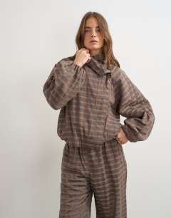 Model wearing Co-ord check funnel neck bomber in brown