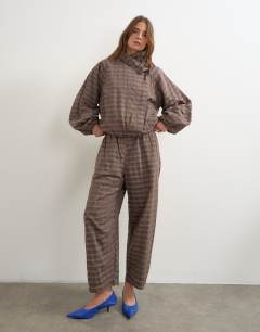 Model wearing Co-ord check funnel neck bomber in brown