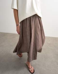 Model wearing Co ord check tie waist pleated maxi skirt in brown