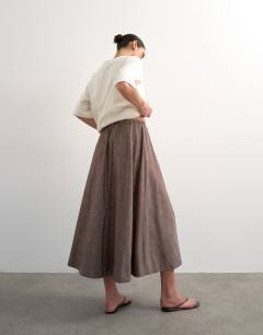 Model wearing Co ord check tie waist pleated maxi skirt in brown