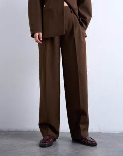 Model wearing Co ord double pleat suit trouser in brown 