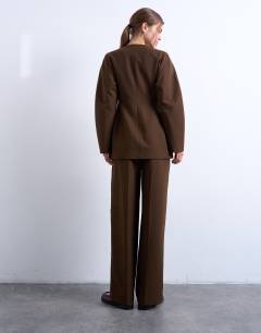 Model wearing Co ord double pleat suit trouser in brown 