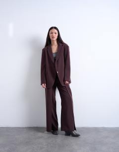 Model wearing Co ord double pleated straight leg trouser in plum chocolate