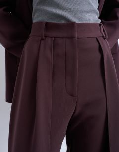 Model wearing Co ord double pleated straight leg trouser in plum chocolate
