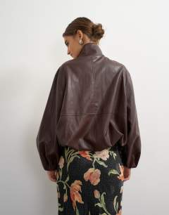 Model wearing Co-ord faux leather funnel neck bubble hem top in chocolate