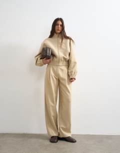 Model wearing Co ord funnel neck jacket in sand