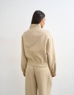 Model wearing Co ord funnel neck jacket in sand