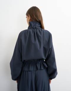 Model wearing Co ord funnel neck jacket with tie waist in navy