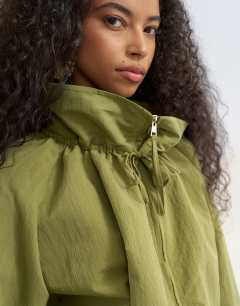 Model wearing Co ord funnel neck jacket with tie waist in olive
