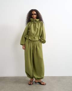 Model wearing Co ord funnel neck jacket with tie waist in olive