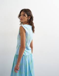 Model wearing Co-ord grown on neck pin tuck top in blue check