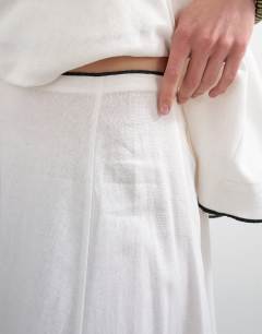 Model wearing Co-ord heavy linen rich maxi skirt with black contrast piping in white