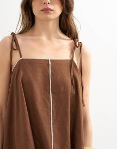 Model wearing Co-ord linen rich cami top with ecru contrast piping in brown