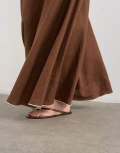 Model wearing Co-ord linen rich maxi skirt with contrast piping in brown