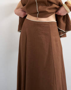 Model wearing Co-ord linen rich maxi skirt with contrast piping in brown