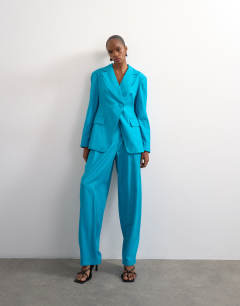 Model wearing Co ord occasion strong shoulder cinched waist blazer in turquoise