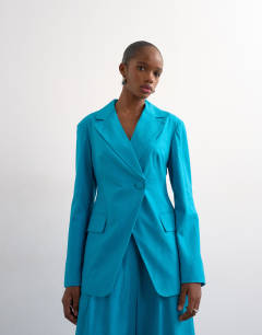 Model wearing Co ord occasion strong shoulder cinched waist blazer in turquoise