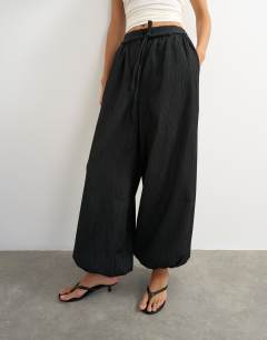 Model wearing Co ord occassion plisse balloon tie front trouser in black