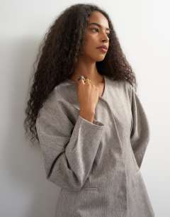 Model wearing Co ord ovoid sleeve collarless blazer in taupe marl