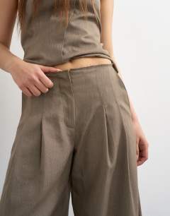 Model wearing Co ord raw hem barrel leg tailored trouser in brown