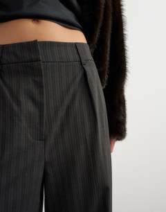 Model wearing Co ord stripe double pleat tab trouser in brown and black stripe