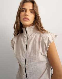 Model wearing Co-ord techy high neck short sleeved zip through top in ecru