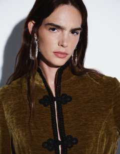 Model wearing Co-ord velvet knot detail jacket with nero collar in green