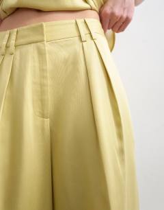 Model wearing Co ord wedding guest occasion pleated slouchy leg trouser in buttermilk