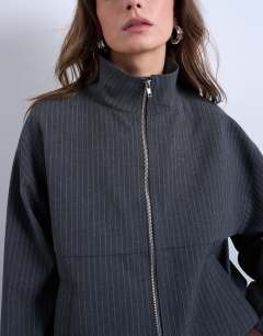 Model wearing Co rd funnel neck jacket in charcoal stripe