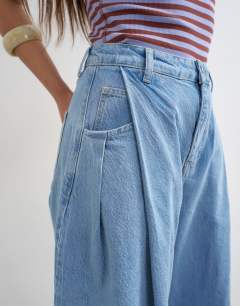 Model wearing Cocoon mid rise barrel jean in bleach